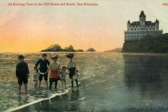 Vintage postcard of people standing at the shore with waves touching their feet; in the background, San Francisco’s historic Cliff House sits on a bluff overlooking the beach at sunset.