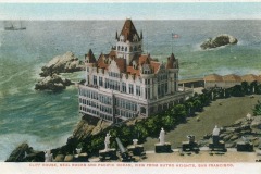 Historic postcard showing San Francisco’s Cliff House, a grand Victorian building perched above the Pacific Ocean, with Seal Rocks in the water and benches along a scenic overlook in the foreground.