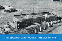 Black and white photo of the Second Cliff House on San Francisco’s rocky coastline, surrounded by water. The building is labeled as rebuilt in 1864. Text at the bottom reads, The Second Cliff House—Rebuilt in 1864.
