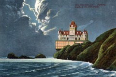 Cliff House, a historic landmark in San Francisco, sits dramatically on a rocky coastline the stormy sky over the ocean and waves crash against the shore below.