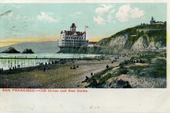 Vintage postcard of San Francisco’s iconic Cliff House perched on a bluff above the ocean, with Seal Rocks offshore. People stroll along the beach as a pier stretches into the water beneath a pastel sky.