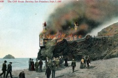People watch from the beach as San Francisco’s iconic Cliff House burns, with large flames and smoke engulfing the building perched on a rocky cliff, dated September 7, 1907.