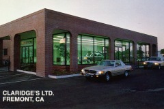 Exterior view of a brick building with large green-tinted windows and rounded arches. Two cars are parked in the front. Text on the image reads CLARIDGES LTD. FREMONT, CA.