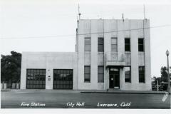 A vintage black and white photo shows a mid-20th-century building labeled City Hall and Fire Station with three garage doors on the left. The words Livermore, Calif. are visible at the bottom.