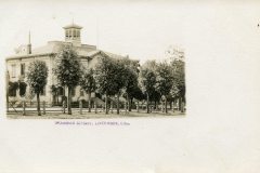 A vintage photograph of Grammar School in Livermore, California. The building features two stories with a central cupola and is surrounded by trees. A wooden fence lines the perimeter.