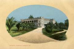 A vintage postcard image shows a grand, rectangular building labeled as Hydropathic Sanitarium, Livermore, Cal. The structure is surrounded by lush greenery and a dirt path leading to its entrance, under a clear blue sky.