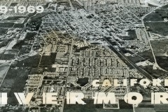 Aerial view of Livermore, California, showing a grid of streets, residential areas, and surrounding farmland. The image has text reading 1869-1969 CALIFORNIA LIVERMORE across the top and bottom.
