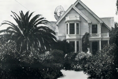 A vintage photo of a large Victorian-style house labeled Residence of Israel Horton, Livermore. The house features a prominent bay window, gabled roof, and a dish antenna. A lush garden with large palm trees surrounds the front yard.