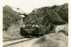 Vintage black-and-white photo of a gravity train labeled Gravity No. 15 on Mt. Tamalpais and Muir Woods Railway, California. Train is on tracks between rocky hillsides, carrying passengers.