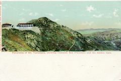 A vintage postcard showing a panorama from Mt. Tamalpais. The view includes a mountain landscape with a building on the slope. In the distance, Oakland, San Francisco, and the Golden Gate area are visible.