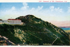 A vintage postcard illustration of Mt. Tamalpais in California. It features a view of the summit with a building labeled Tavern of Tamalpais. The landscape shows rugged terrain under a blue sky with distant water visible.