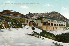 Vintage postcard of The Tavern on Mount Tamalpais, California, in winter. The building is set against a snow-dusted hill with a clear sky. The architecture features a long, covered porch and large windows.