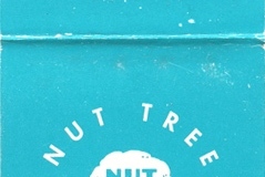 A teal matchbook cover with white text reading Nut Tree California. The design features a white circular logo with a tree in the center. The bottom has text about the manufacturers location in Sacramento, California.