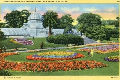 Vintage postcard of the Conservatory of Flowers in Golden Gate Park, San Francisco. Features a domed glass greenhouse, colorful flowerbeds, a sign reading San Francisco Welcomes You, palm trees, and visitors strolling in the garden.