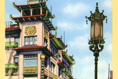 Vintage postcard illustrating a business district in Chinatown, San Francisco. The scene features a building with Chinese architectural elements, vibrant signs, and ornate street lamps against a clear blue sky.