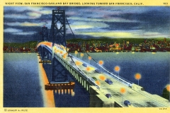 Vintage postcard depicting the San Francisco-Oakland Bay Bridge at night. The bridge is illuminated with yellow lights, and cars are visible crossing. The San Francisco cityscape is faintly visible in the background.