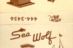 Vintage matchbook with illustrations and text. The top reads Sea Wolf Restaurant in retro font, showcasing a small building sketch reminiscent of Jack London Square. The bottom features a building and sailboat, with contact number and address also visible. Colors are brown on beige.