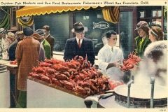 People in vintage attire gather around an outdoor seafood market at Fishermans Wharf, San Francisco. A chef in a white uniform holds a large crab. Crabs are displayed on a counter, with steam rising from cooking pots. A sign reads DINNERS.