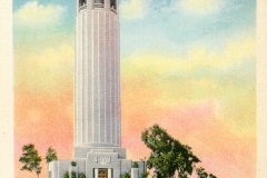 Vintage postcard of Coit Tower on Telegraph Hill, San Francisco. The tall, cylindrical building is surrounded by trees and a garden in the foreground. The sky displays pastel shades of pink and orange, suggesting sunset or sunrise.